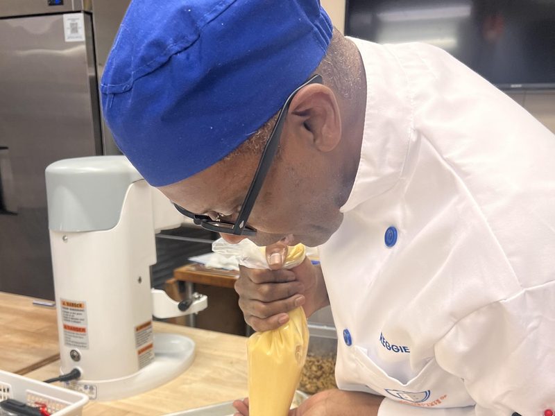 Reggie Edwards piping choux in the kitchen